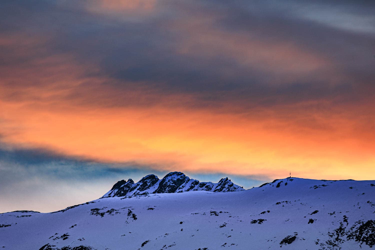 Kräftiges Abendrot über dem Berggipfel im Wallis
